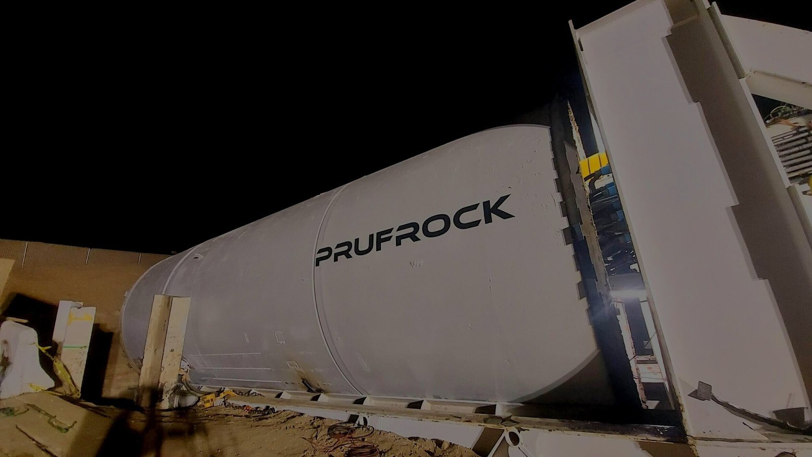 Prufrock tunnel boring machine labeled on the white cylinder at night